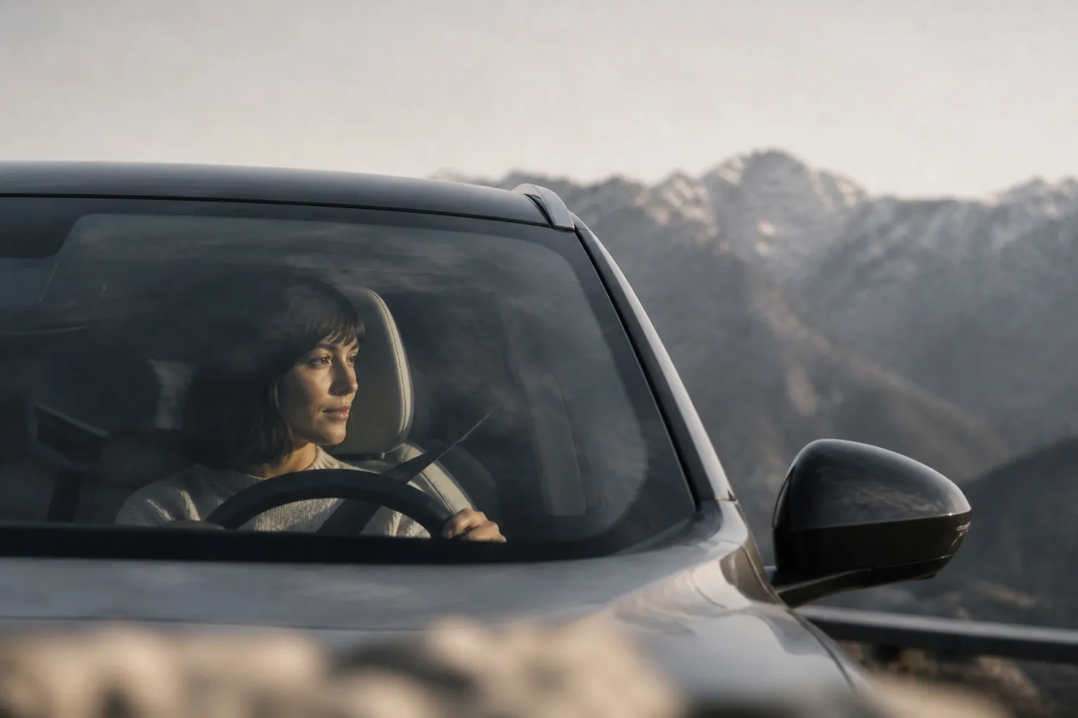 Conductrice au volant d'une Tesla Model Y sur une route de montagne